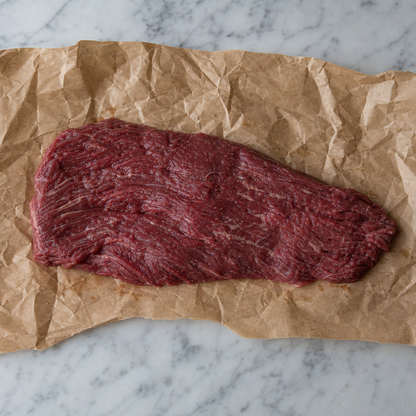 Rauwe bavet op bruin papier, plat liggend in de lengte op een lichte marmeren ondergrond