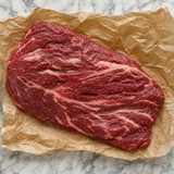 Rauw Fat Angus bavetstuk met grove vetdooradering op bruin bakpapier