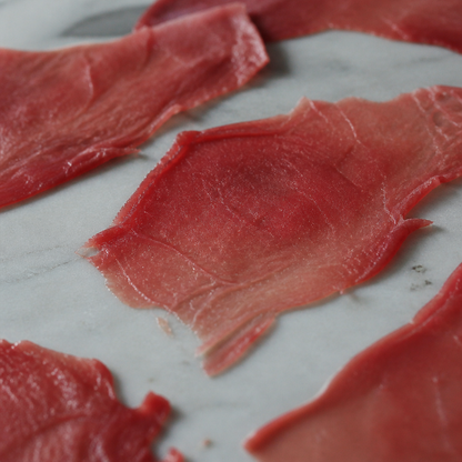 Flinterdunne plakjes Angus carpaccio op een lichte ondergrond