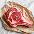 Rauwe côte de boeuf met bot en veel marmering op bruin papier