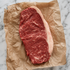 Rauwe Fat Angus entrecote met stevige vetrand op bruin papier