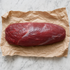 Hele kogel van rundvlees op bruin papier, klaar om in steaks te snijden