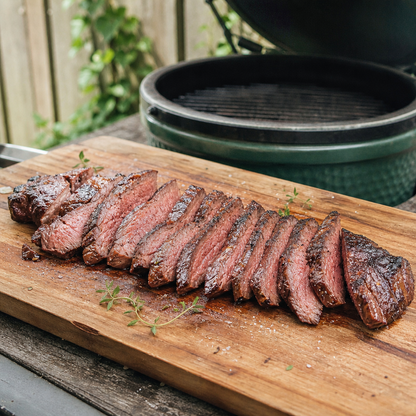 Gesneden Fat Angus longhaas met gegrilde korst op houten plank, naast barbecue