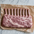 Rauw Iberico rack met botjes op bakpapier, klaar voor BBQ of oven