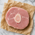Rauwe kalfs ossobuco schijf met beenmerg, plat op bakpapier op marmeren ondergrond