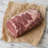 Hele rib-eye van rundvlees met fijne vetdooradering op kraftpapier