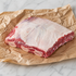 Rauw stuk rundershort rib met bot, op bruin papier op een licht marmeren ondergrond