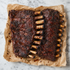 Indisch gegaarde spareribs met glanzende kruidige lak op bakpapier